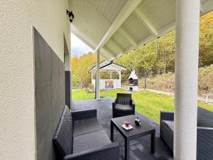 a patio with chairs and a table and a grill at Między Wzgórzami Korbielów in Korbielów