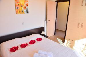 a bedroom with a bed with red roses on it at Villa Eli Keratokampos in Kastrí