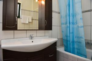 a bathroom with a sink and a blue shower curtain at Villa Eli Keratokampos in Kastrí +33 photos