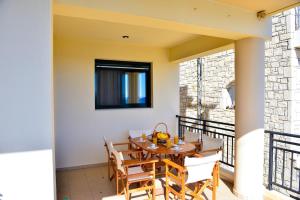 a dining room with a table and chairs on a balcony at Villa Eli Keratokampos in Kastrí
