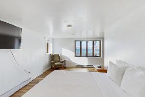 a white bedroom with a bed and a tv at Live Laugh Lake - A in Rushville