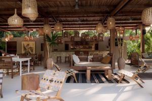 a restaurant with chairs and tables and a bar at Cala Luna Boutique Hotel & Villas in Tamarindo
