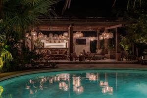 a swimming pool at night with chandeliers at Cala Luna Boutique Hotel & Villas in Tamarindo