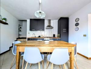 a dining room with a wooden table and white chairs at Rooftop Carcente in San Siro