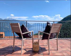 two chairs with pillows sitting on a balcony overlooking the water at Rooftop Carcente in San Siro