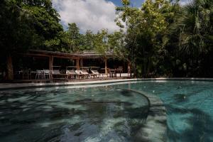 a swimming pool with chairs and a pavilion at Cala Luna Boutique Hotel & Villas in Tamarindo +104 photos