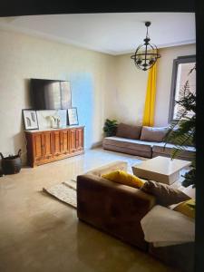 a living room with a couch and a tv at Airport Luxury Residence Taj collection 1 in Casablanca