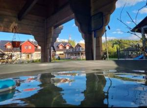 a pool of water in a backyard with houses in the background at Ostoja Karkonoska in Podgórzyn