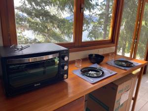 a microwave sitting on a counter in a kitchen at Cabaña Sobre Playa Lago Gutiérrez 2 in San Carlos de Bariloche