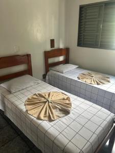 two beds with bows on them in a room at Hotel Ravena Araraquara in Araraquara