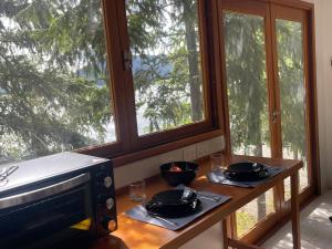 a kitchen with a table with two glasses and a microwave at Cabaña Sobre Playa Lago Gutiérrez 2 in San Carlos de Bariloche +23 photos