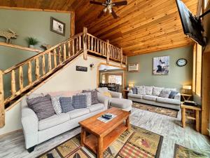 a living room with a couch and a staircase at Riverfront Motel & Cabins in Thompson Falls