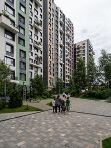 a group of people standing in front of tall buildings at Smart Lux 200 in Zhezdi