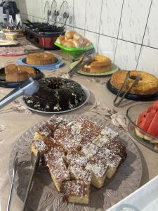 a table topped with different types of cakes and pastries at Hotel Ravena Araraquara in Araraquara