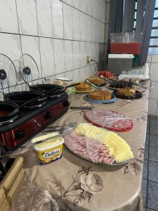 a table with many plates of food on it at Hotel Ravena Araraquara in Araraquara +26 photos