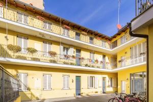 a yellow building with balconies and bikes parked in front at Malpensa sweet home in Busto Arsizio