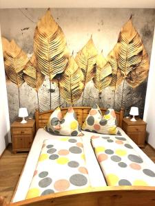 a bedroom with a bed with leaves on the wall at Haus Schloßbergblick in Leutschach