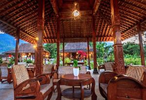 a patio with a table and chairs in a pavilion at Balkondes Majaksingi in Borobudur