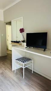 a living room with a tv on a white wall at Midrand Manor Guesthouse in Midrand