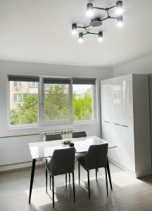 a dining room with a white table and chairs at Apartament Karim in Drobeta-Turnu Severin