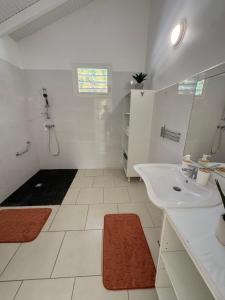 a white bathroom with a sink and a shower at Golden Vibes in Petit-Bourg