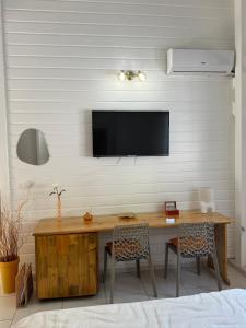 a room with a desk with a television on a wall at Golden Vibes in Petit-Bourg