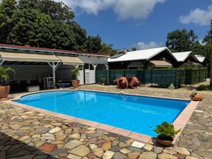 a swimming pool in front of a house at Golden Vibes in Petit-Bourg