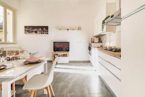 a white kitchen with a table and a dining room at Malpensa sweet home in Busto Arsizio