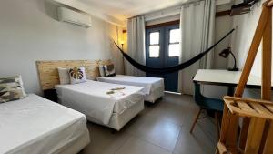 a room with two beds and a hammock in it at Pousada VilaZinha in Vila Velha