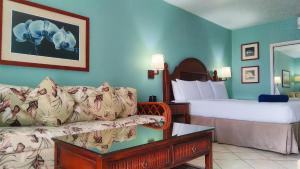 a hotel room with a couch and a bed at Trade Winds Hotel Antigua in Dickenson Bay +5 photos