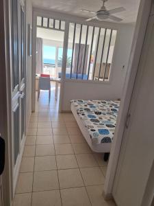 a bedroom with a bed and a view of the ocean at Apartamento PinkFloyd im Palm Garden in Morro del Jable +6 photos