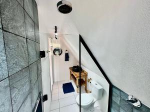 a small bathroom with a toilet and a staircase at Chalé da Árvore in Urubici