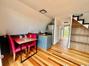 a kitchen with a table and red chairs in a room at Chalé da Árvore in Urubici