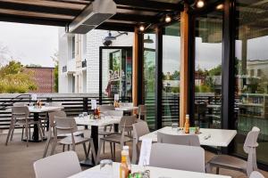 a restaurant with white tables and chairs and windows at Hillside Retreat with Hot Tub & Sweeping City Views in Salt Lake City