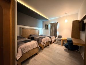 a hotel room with two beds and a desk at Hotel Los Diamantes in Rancho Los Limones +54 photos