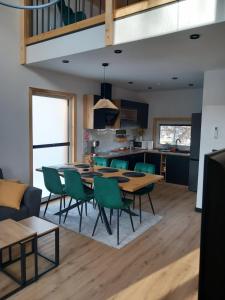 a dining room and kitchen with a table and chairs at LoftLove roztocze domek in Jędrzejówka