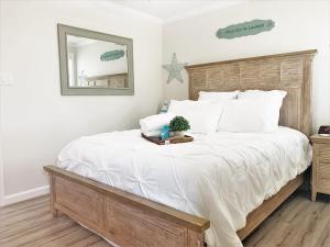 a bedroom with a large bed with white sheets and a mirror at FUN! PoolLake near Disney Fast WiFi Pickleball in Clermont +39 photos