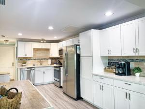 a kitchen with white cabinets and a stainless steel refrigerator at FUN! PoolLake near Disney Fast WiFi Pickleball in Clermont
