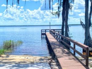 a wooden bridge over a large body of water at FUN! PoolLake near Disney Fast WiFi Pickleball in Clermont