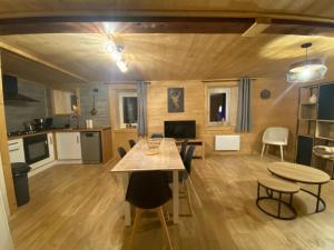 a kitchen and living room with a table and chairs at Le Logis des Cerfs in Les Angles