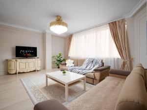 a living room with a couch and a table at Smart Lux 320 in Almaty