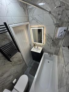 a bathroom with a tub and a toilet and a sink at Minstead Houses - 5 Bedroom Contractor House Sleeps 9 Parking for 2 Vans Near Bromford Duddeston Fort Dunlop Star City HS2 in Birmingham +13 photos