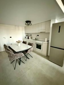 a kitchen with a table and chairs and a refrigerator at Infinity Loft Residence in Târgu Jiu