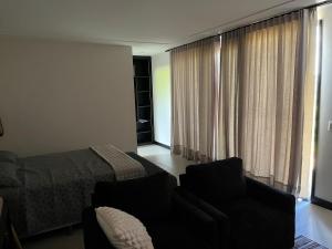 a bedroom with a bed and a couch and a chair at Le Chateau Lavande in Balsa Nova +25 photos