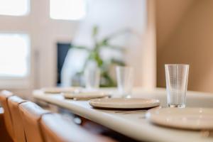 a long table with plates and glasses on it at Charming Appleton Condo Downtown Modern Loft in Appleton +4 photos