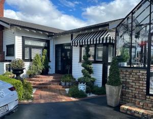 a house with a car parked in front of it at La Belle Maison in Tauranga +16 photos