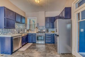 a kitchen with blue cabinets and a refrigerator at Rosemont in Florence +31 photos