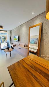 a living room with a table and a mirror at Sunset Villas Milagres - Casa Anahi in Passo de Camarajibe