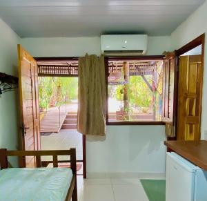 a kitchen with a window with a view of a porch at POUSADA FLORA in Alter do Chao +49 photos