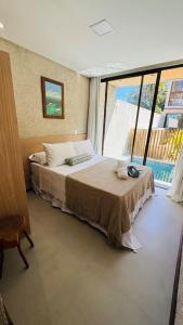 a bedroom with a bed and a large window at Sunset Villas Milagres - Casa Anahi in Passo de Camarajibe +32 photos